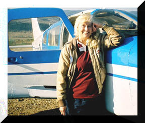 Dr. Penny Hamilton standing beside her airplane